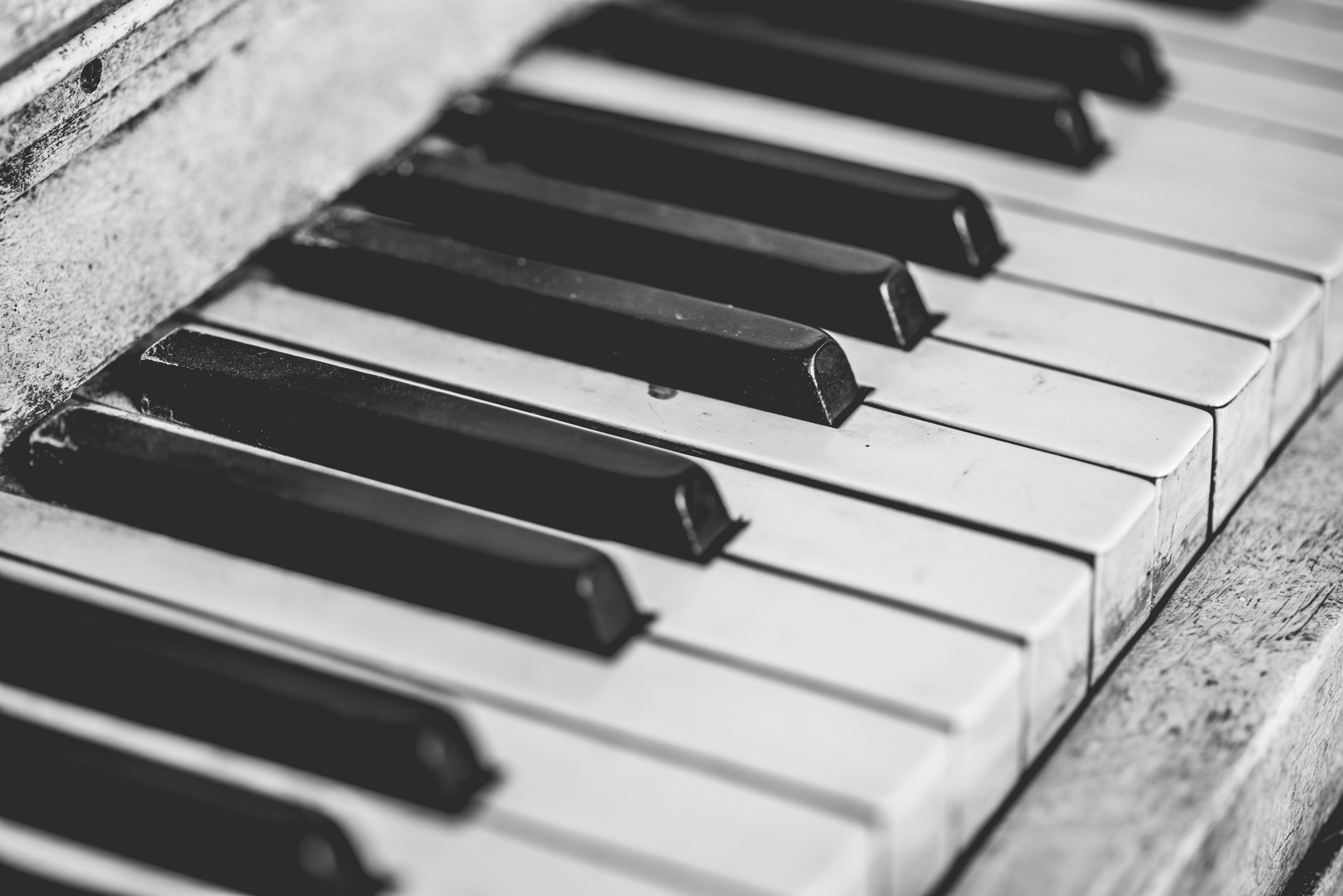 A close-up black and white photo of vintage piano keys, showcasing classic musical instrument detail.